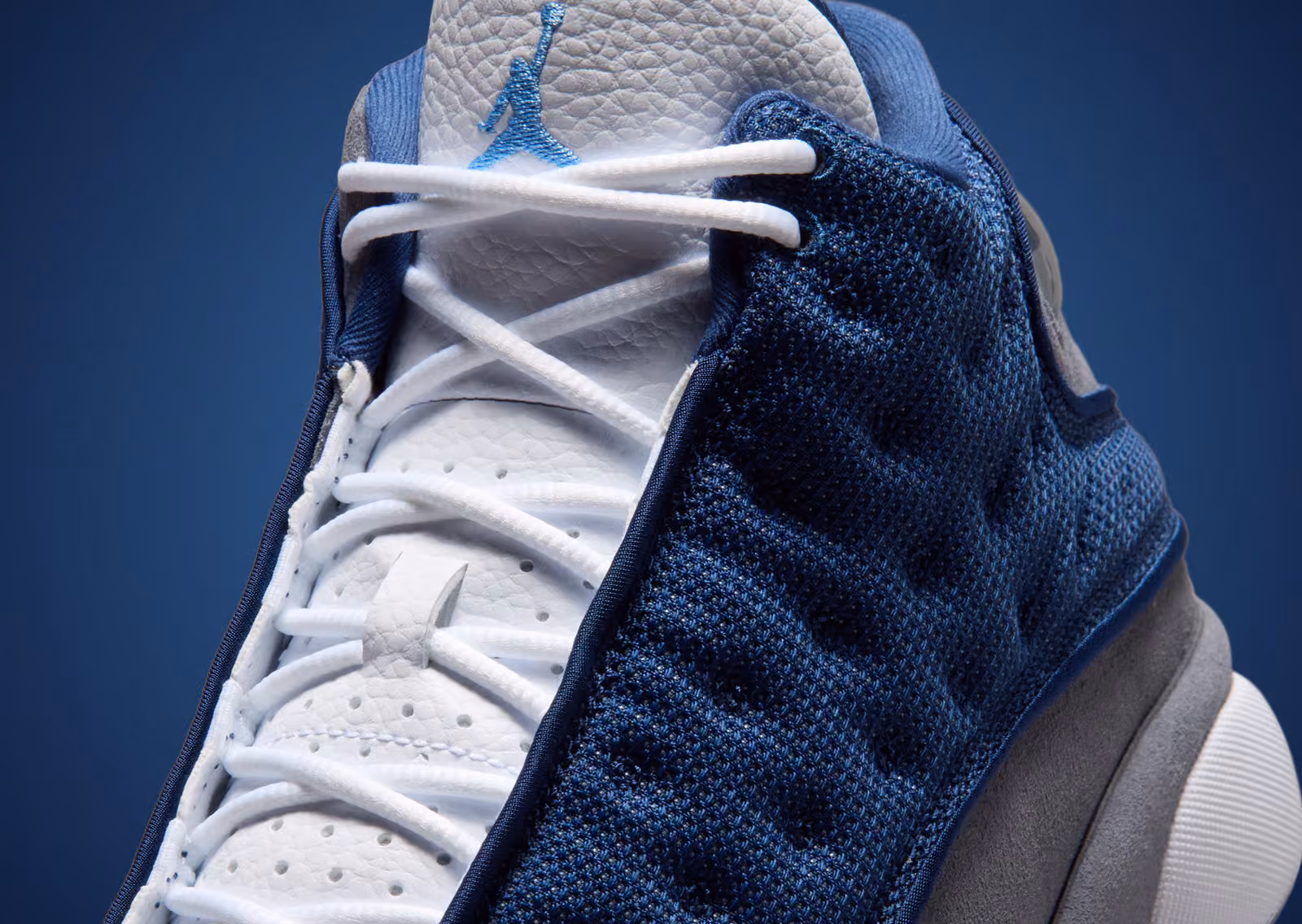 Air Jordan 13 Flint 2026 close-up of tongue Jumpman logo and navy mesh weave