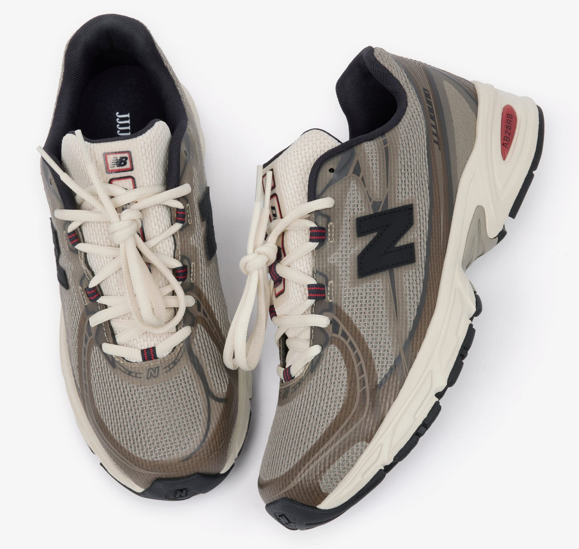 Top-down studio view of the JJJJound x New Balance 740N Mushroom pair showing the taupe mesh upper, off-white laces, navy collar trim and black N logo