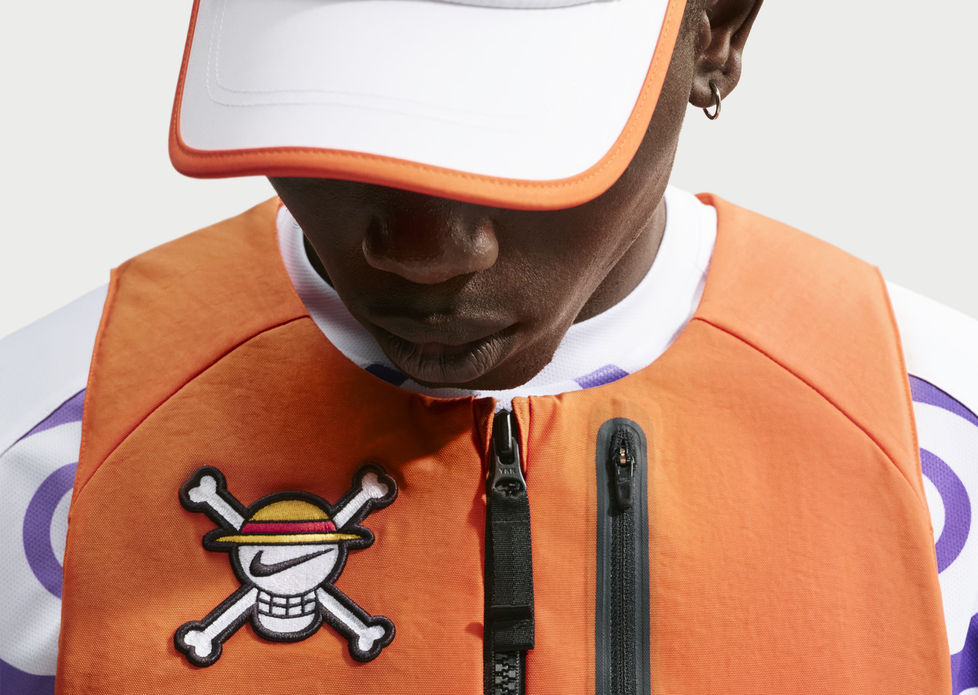 One Piece x Nike vest in orange with the Jolly Roger emblem on the chest