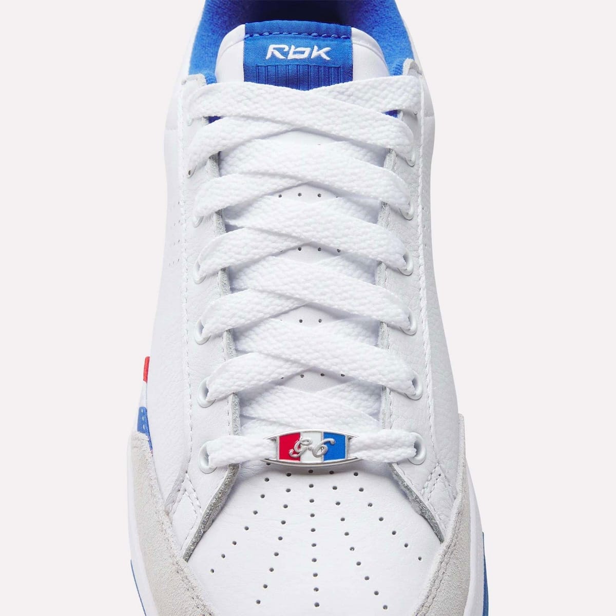 Close-up of the Reebok G-Unit G6 toe box showing the silver G-6 lace dubrae with red white and blue plate and the Rbk tongue tag