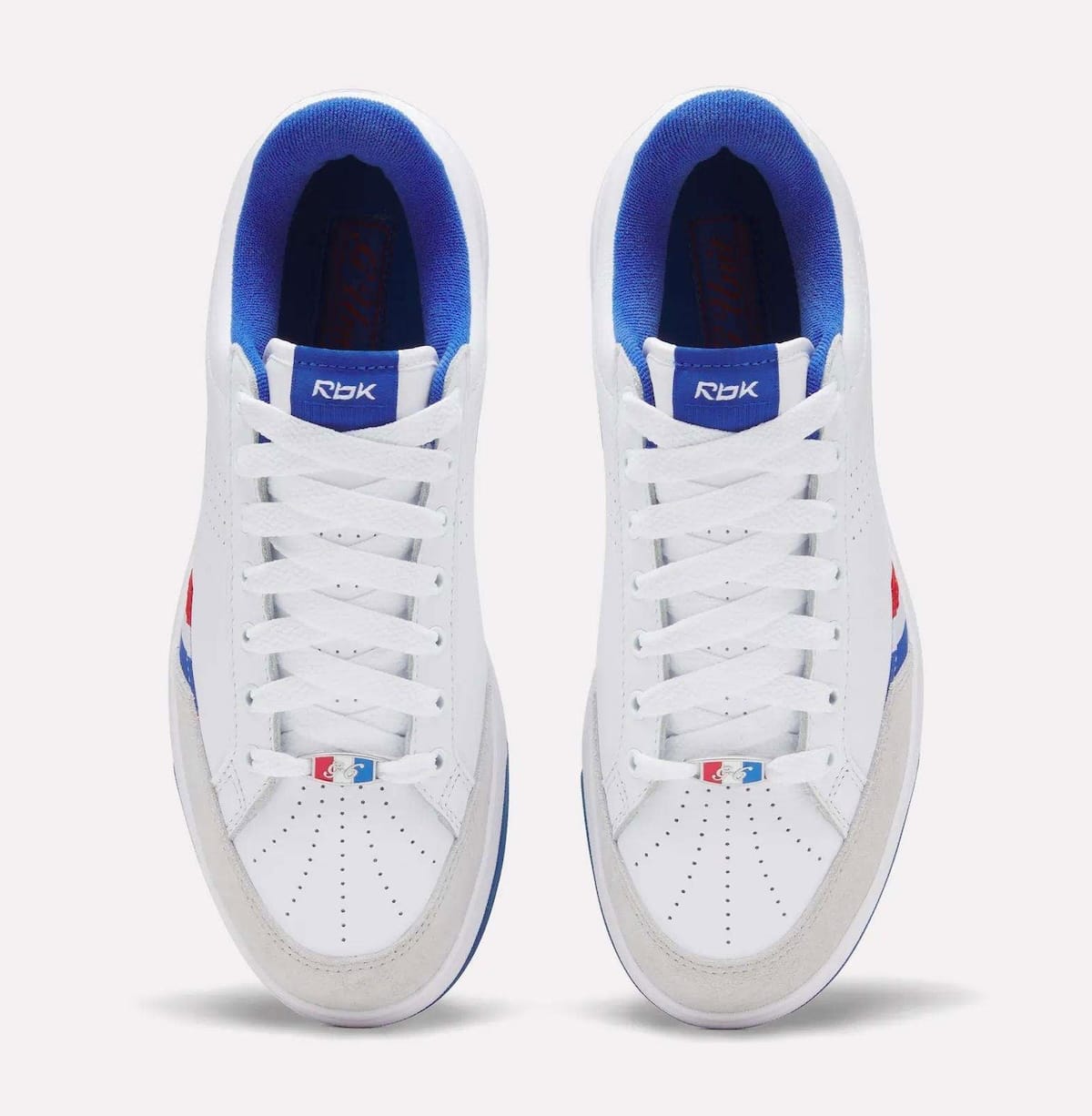 Top-down view of the Reebok G-Unit G6 pair in white leather with grey suede toes, royal blue collar lining and Rbk tongue tags
