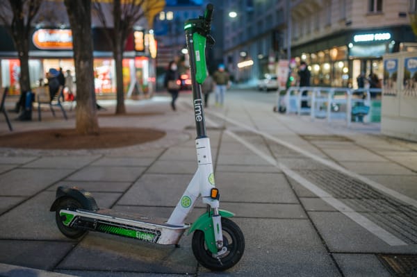 A Lime shared electric scooter parked on a sidewalk, as the company completed its Nasdaq IPO.