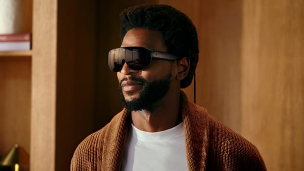 A man wearing Meta VR Glasses, a slim dark visor-style VR device with a tether cable